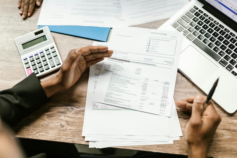 A printed bank statement next to a laptop